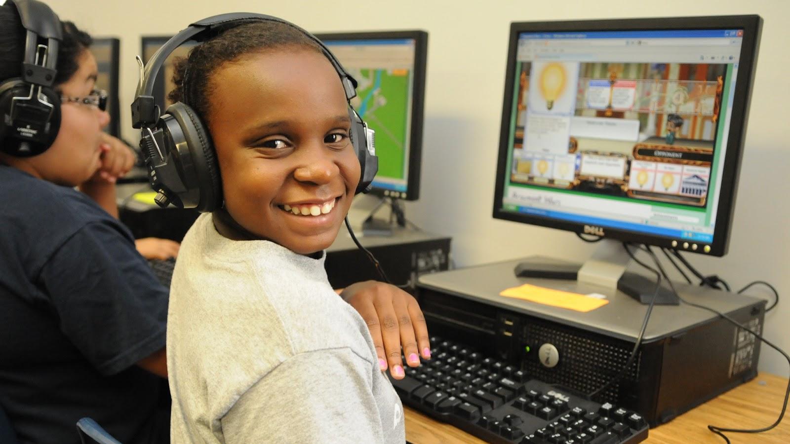 A child smiling while using a computer