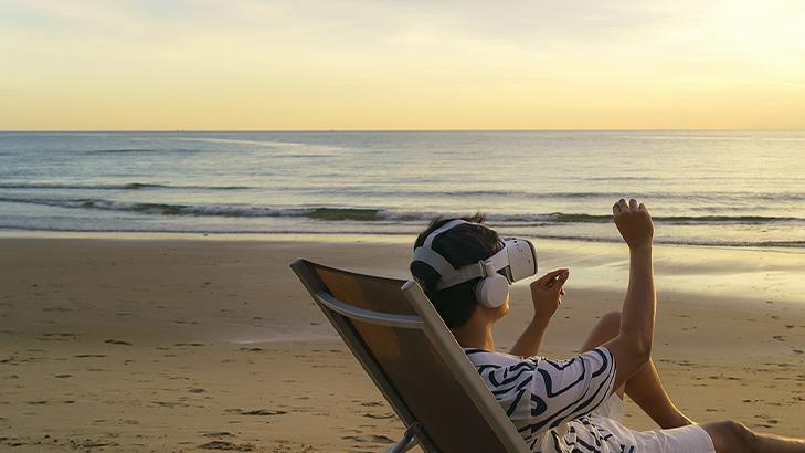 man on beach sunset with VR headset on