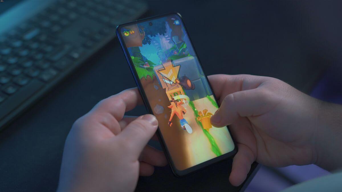 Image of hands holding a smartphone while playing a mobile game | Hero image for "Looking to boost your game’s LTV? Try an on-device advertising campaign"