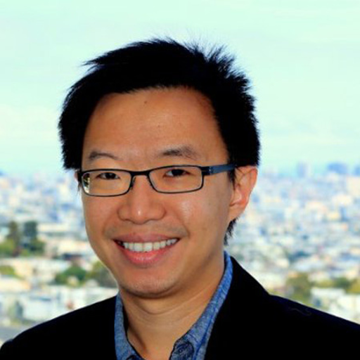 Face of man wearing glasses and a blue shirt with a black jacket