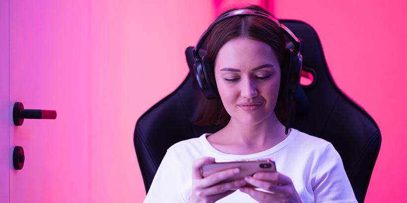 Girl sitting on a computer chair looking at a phone